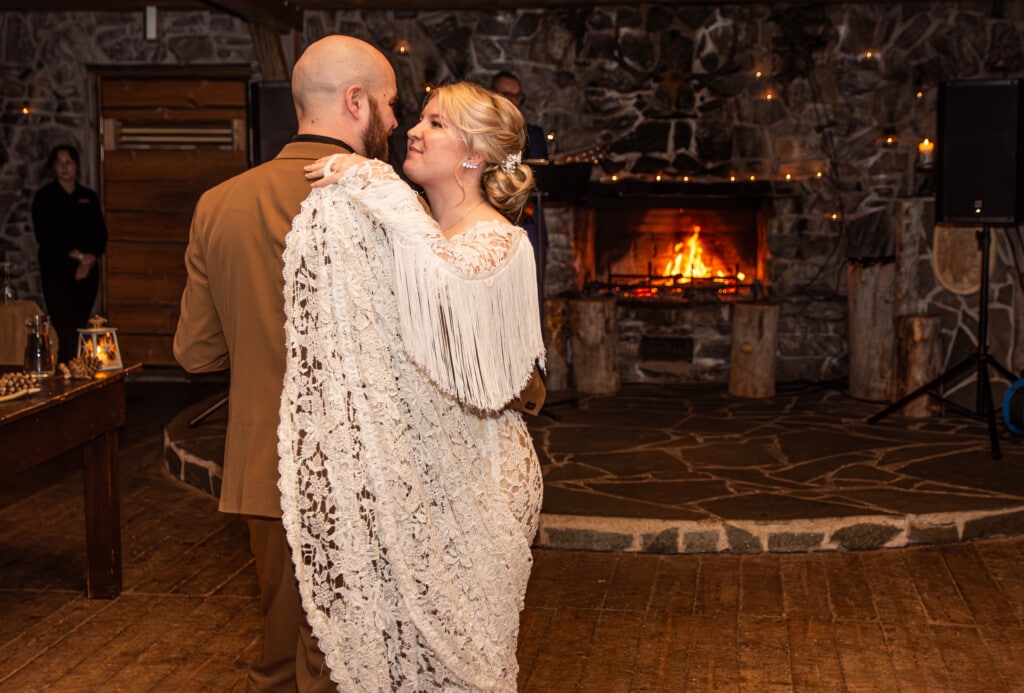 Bride and groom dancing their first dance inside a beautifully decorated log restaurant surrounded by the forests of Ruka-Kuusamo, Finland.